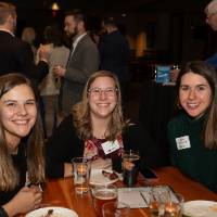 three alumni smiling and taking a picture